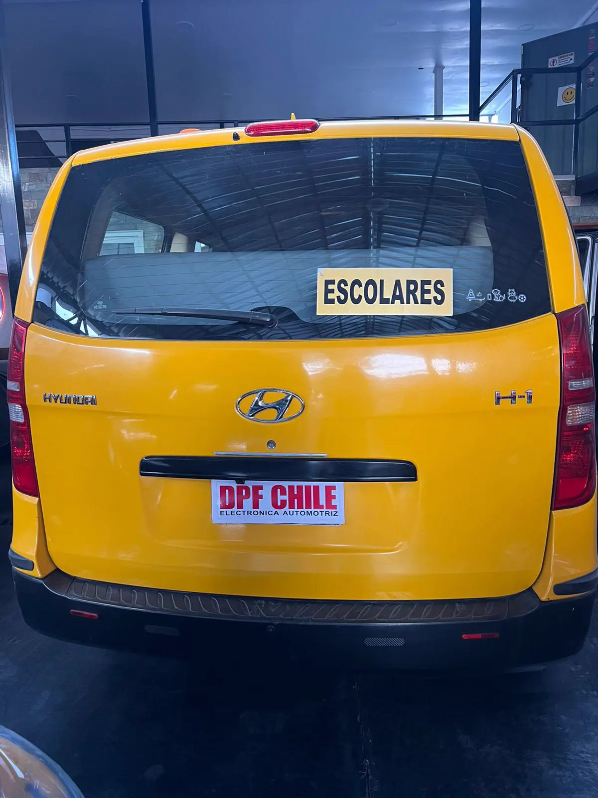 Furgón de transporte escolar Hyundai H-1 con placa corporativa oficial DPF CHILE.