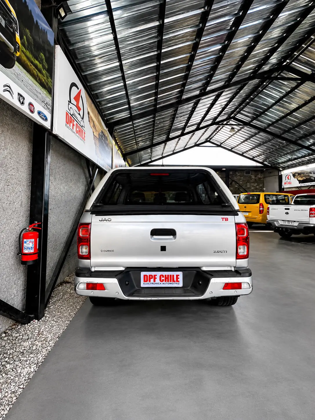 Camioneta JAC T8 con placa DPF CHILE en bahía techada con señalética oficial.