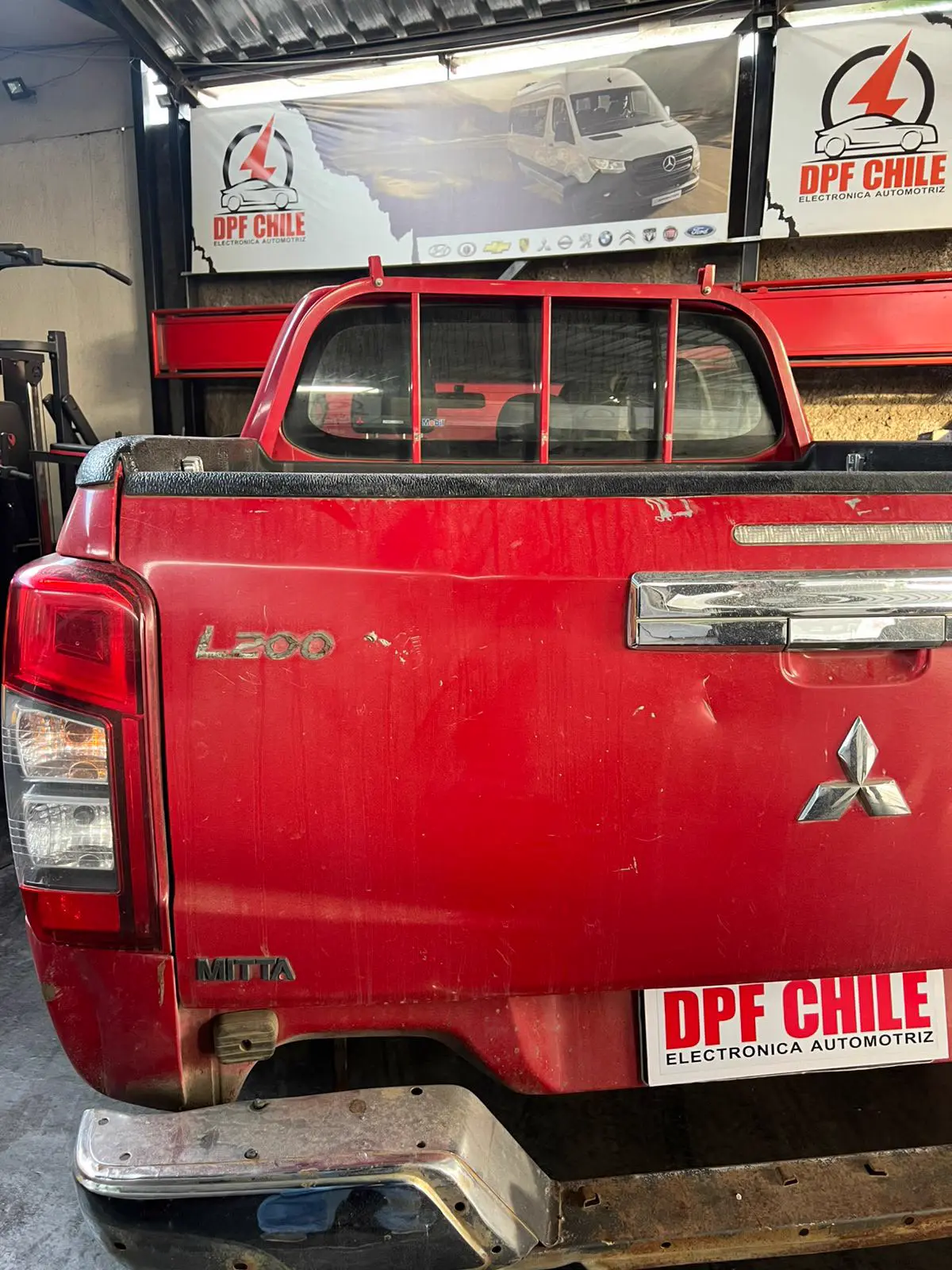 Camioneta 4x4 Mitsubishi L200 en módulo de servicio y diagnóstico computarizado.