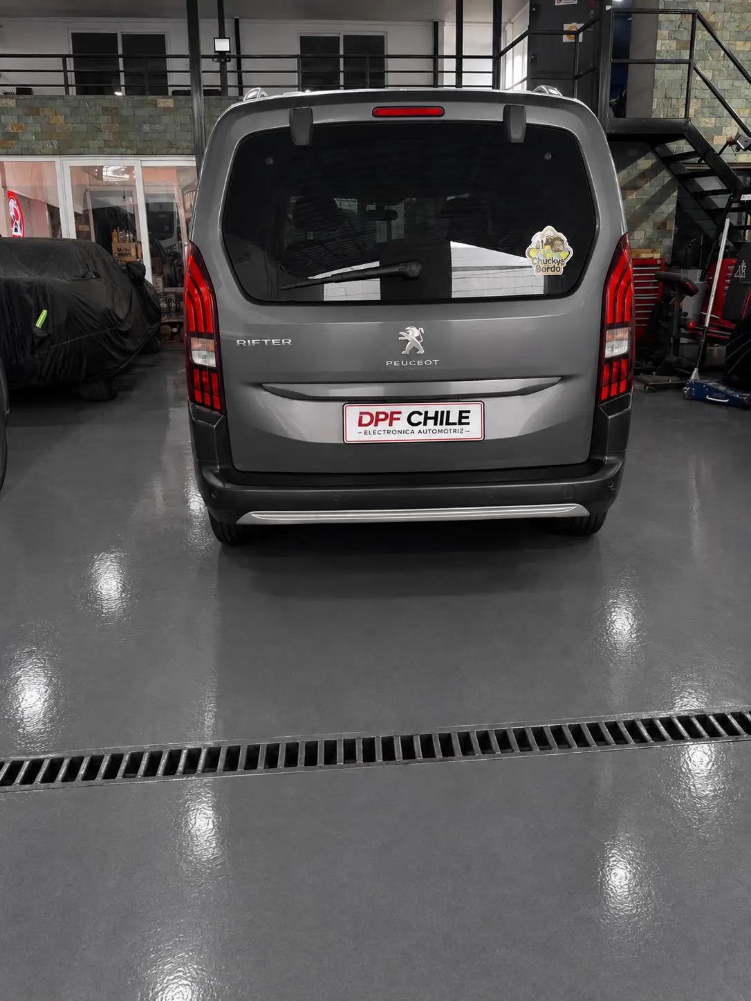 Vehículo Peugeot Rifter en piso epóxico de alta resistencia en taller.